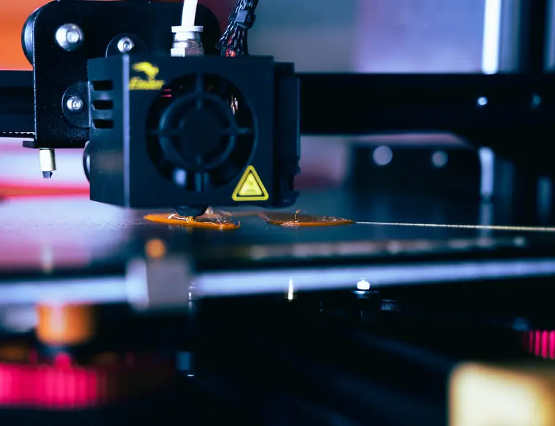 Detailed view of a 3D printer head during operation, showcasing modern printing technology